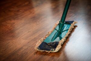 Dust mop on brown hardwood flooring